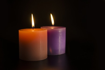 two burning candles pink and violet isolatedの写真素材