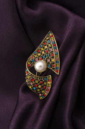 vintage brooch with pearl and colored diamonds isolated on silkの写真素材