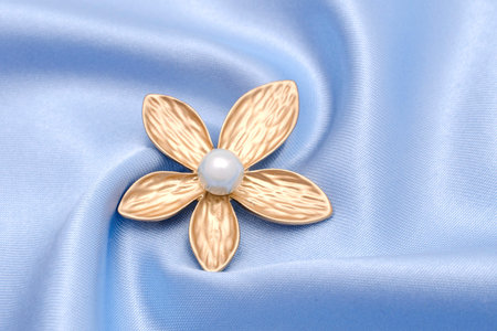golden brooch flower with pearl isolated on silkの写真素材