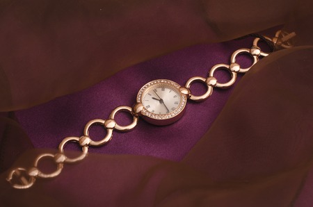 women's gold wrist watches with diamonds isolated on silkの写真素材