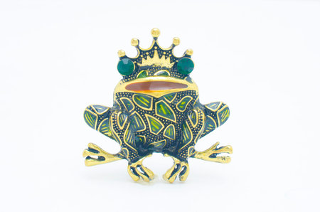 golden enamelled brooch frog wearing a crown isolated on white