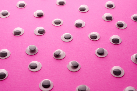plastic eyes on a pink backgroundの写真素材