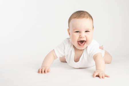 portrait of a smiling baby lying on his stomachの写真素材