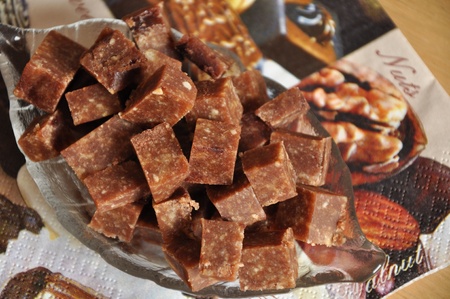 A lot of chocolate cubes with nuts in glass dish.の写真素材