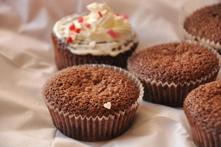 Chocolate fancy cakes with sweet hearts in paper moulds.の写真素材