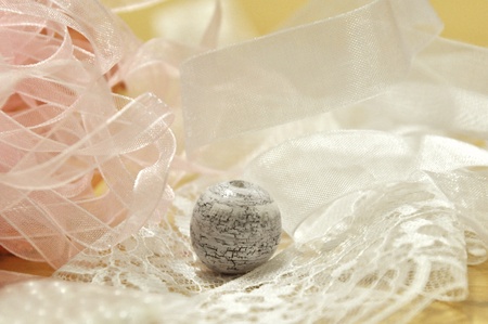 White shabby bead in stack of lace and ribbons.の写真素材