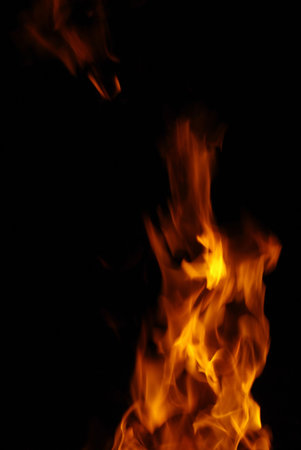 Tongue of orange flame isolated on black background