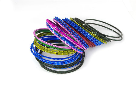 Coloured metallic bracelet rings on white background