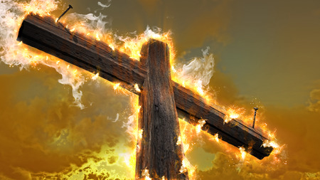 Wooden cross against the sky in fireの写真素材