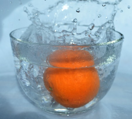orange fruit  is falling and splashing into water incolor .   Concept of timeの写真素材