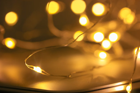 Yellow lights of the New Year's Eve garland, blurred back festive background