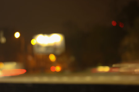 Car traffic on the road in the night city and blurred lights of headlights and bigboards. Abstract...