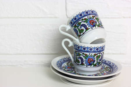 Two traditional Turkish coffee cups isolated on white brick wall background. High quality photoの写真素材