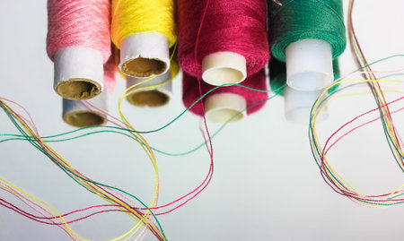 Multicolored threads in the coils are reflected on the surface of the mirror. Sewing and needlework. High quality photoの写真素材