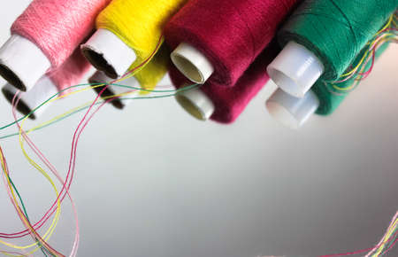 Multicolored threads in the coils are reflected on the surface of the mirror. Sewing and needlework. High quality photoの写真素材