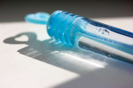Blue plastic bottle of soap bubbles isolated on white background. Contrast shadows from the soap bubble jar. A toy for children's fun.の写真素材