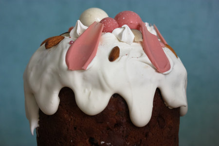 Easter cake decorated with white icing, meringue, pink decorative chocolate balls, nuts. Homemade...