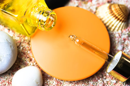 Dropper bottle with essential oil. Hyaluronic acid, cosmetic serum or essential oil in a bottle on shells, sand background flatly. Sunscreen oil to protect body from sun. Natural cosmetic, skin care.の写真素材