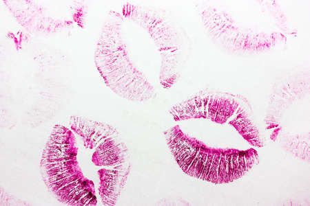Abstract pink kisses isolated on white background. Lots of female lip prints on paper. Beautiful neon lips stamps. Valentine's day, romantic mood and love concept. Lipstick kisses. Print of lipsの写真素材