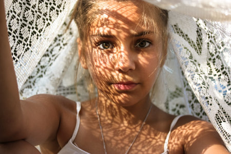 Mysterious portrait of a beautiful mestizo young girl with light shadow pattern on face. Adorable...