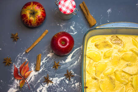Uncooked classic American apple pie in glass baking dish form top view. Step-by-step recipe. Ingredients for cooking - red apples, aniseed spices, cinnamon sticks, dusted flour. Thanksgiving Dessert.の写真素材