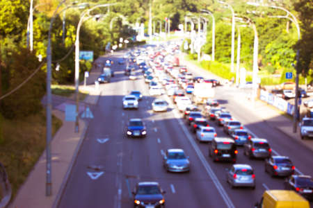 The movement of cars with lights on a road, highway. Blurred photo with the image of cars of different brands of top view. Speed, vehicle traffic at sunny spring or summer day. Big city life, energy.の写真素材