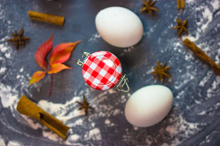 Spice container, white chicken eggs, aniseed spices, cinnamon sticks top view on blue kitchen table. A process of cooking at home. Recipes for preparing natural healthy food at autumn, fall season.の写真素材