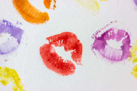 Set of multicolored female lip prints on white paper background top view. Kisses flatly. Lipstick prints, marks. Femininity, flirt, love concept. World Kissing Day. Valentines Day. Lovely backdrop.の写真素材