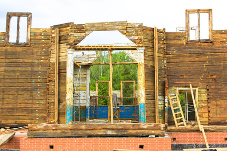 Building a residential wooden house. Facade of unfinished building without roof. A process of...