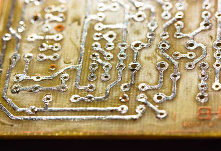 Printed yellow circuit board close-up. Electronic computer hardware technology macro photo. A digital motherboard chip. Microprocessor, transistors, semiconductor made from silicon. Technical science.の写真素材