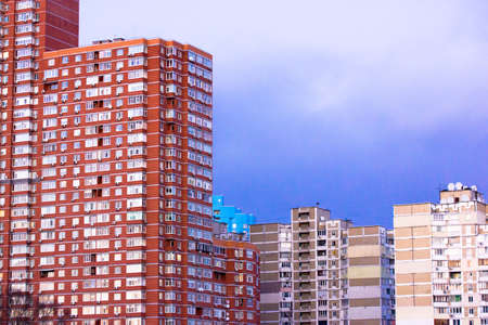 Kyiv, Ukraine. December 1, 2021. Tall modern brick residential building against old ugly Soviet-era buildings, apartment houses against blue sky. Contemporary and outdated architecture. Facade windowsのeditorial素材