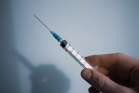 Syringe 2.5 ml disposable sterile in woman's hand on blue background with space for text. Health...