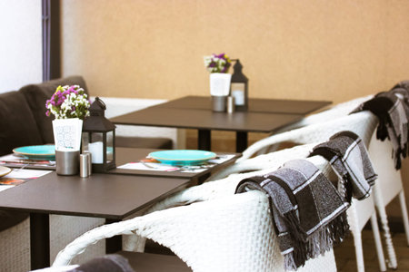 Empty black tables with white chairs on the outdoor summer terrace of a restaurant, cafe. Black and...