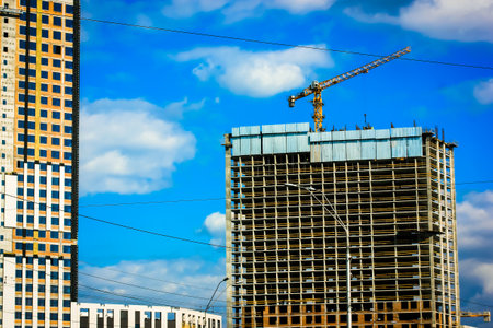 Kyiv, Ukraine. May 1, 2021. Construction site of residential houses. Construction crane against blue sky. A process of glazing a high building facade. high rise condominium house. commercial loans.のeditorial素材