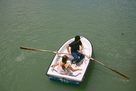Madrid, Spain. June 1, 2022. Faceless man and woman in love floating together in rowing boat on...