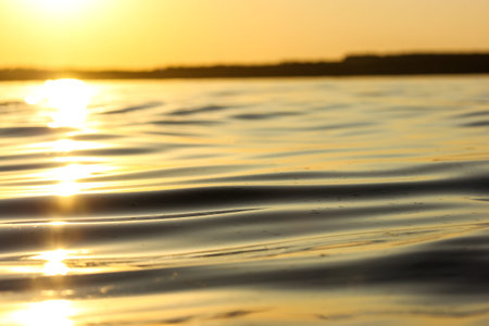 Calm water surface and a horizon view. Soft smooth waves backdrop. The water resource of a river,...