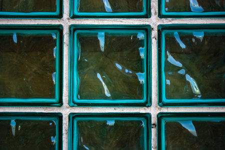 Glass blue green turquoise transparent tile glass wall. Colored glass products for interior, ceramic tile. Glass shiny high glossy blocks for partitions in bathroom. Abstract wallpaper, background.の写真素材