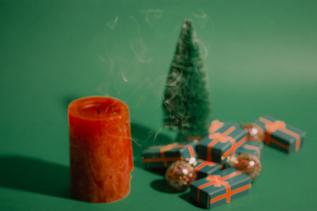 Vintage green Christmas card with decorative toy pine tree and gift boxes, presents for winter holidays. Red extinguished candle, make a wish concept. New Year's Eve 2023 2024 celebrate December Salesの写真素材