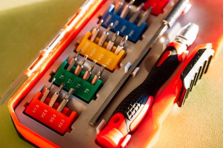 A set of various screwdrivers bits with different attachments in a plastic orange box. Different screwdrivers for repair work. Set of tools for small repairs. Screw driver tip set.の写真素材