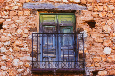 Very old green blue balcony. An ancient red brick house with cracked wooden balconies door, wrought metal railing. Old abandoned building exterior. travel photography. Vintage details of architecture.の写真素材