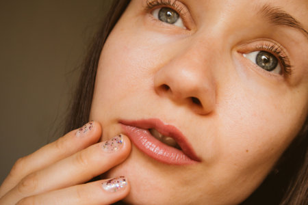 Beautiful white European young woman portrait close-up. A thoughtful, enigmatic girl with gray-blue eyes looking up. Beautiful natural makeup with emphasis on sensual lips. thoughtful female beauty.の写真素材
