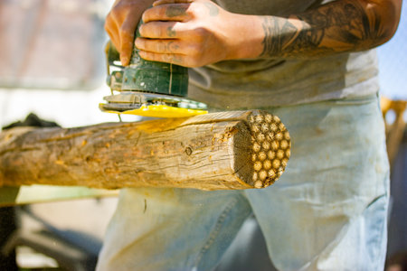 Madrid Spain 1 May 2022 Craftsmans hands with polishing machine on wooden logs. Working on wood with woodworking machine. Carpenter or engineer master working hard. Electric polisher, Orbital sander.のeditorial素材