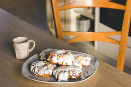 A plate of sweets with white icing, yellow red sprinkles Homemade Donuts, rosquillas, traditional...