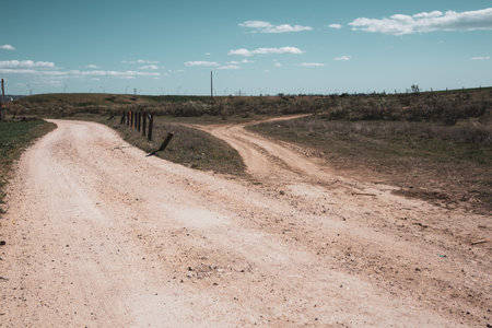 A ramification Country dirt road diverges in two directions - to a right, to a left. Life choices, uncertainty concept. Routes, walkways, trails. Spanish landscape. Two narrow paths Divergence of pathの写真素材