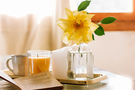 Still life in spring morning A cup of tea, coffee, yellow rose in vase open book