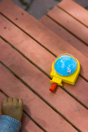 Eduk8 mini cube is a developmental toy for children. A game to develop fine motor skills in pre-school children. Childhood A child is playing with a colorful toy outdoors on playground Selective focusの写真素材