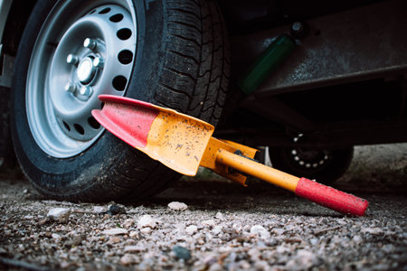 A clamp is used to secure a front wheel of the automobile during transportation, repair. Orange and red wheel blocker. A locker for a car, automobiles. unpaid parking. Booted vehicle on a city street.の写真素材