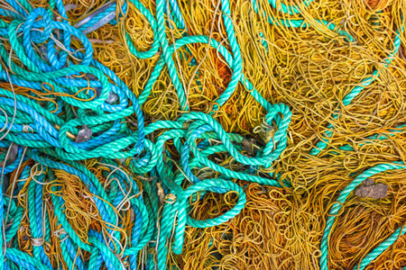 Various rough ropes scattered in a chaotic order, view from above. Brown and blue ropes from above....