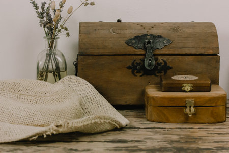 Antique wooden boxes and a vase of dry wildflowers on an old table. Rustic still life with memory about the past. Rusty style chest walnut box for jewelry. Magical faded background. Pirates theme.の写真素材