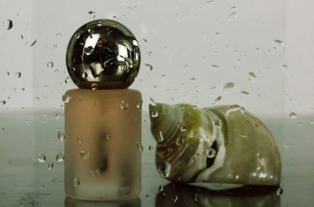 Makeup product, pearl seashell against wet glass with water drops. Stylish modern beauty blog...